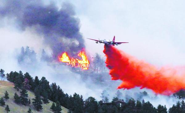 Firefighting plane drops retardant on wildfire.