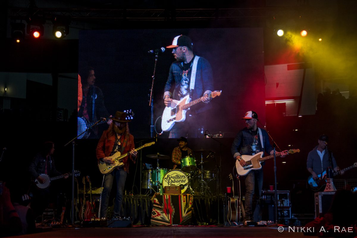 Band performing live on stage with instruments.