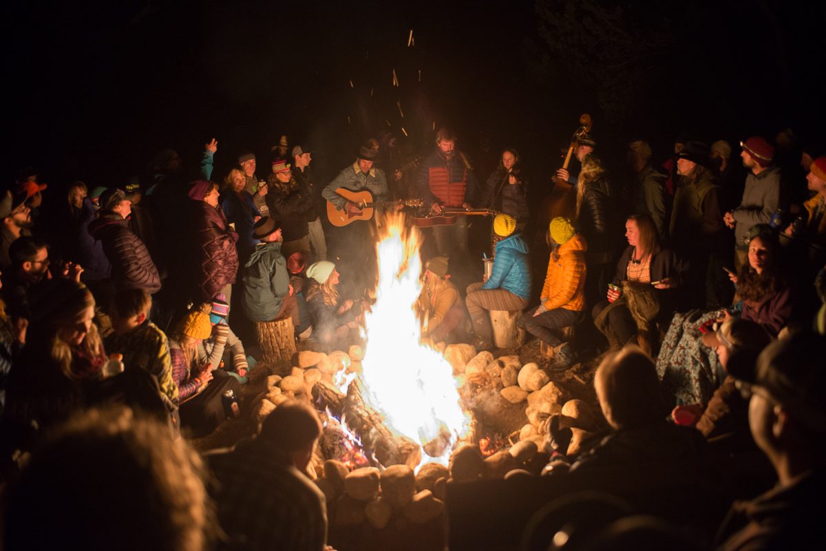 People gathered around a campfire at night.