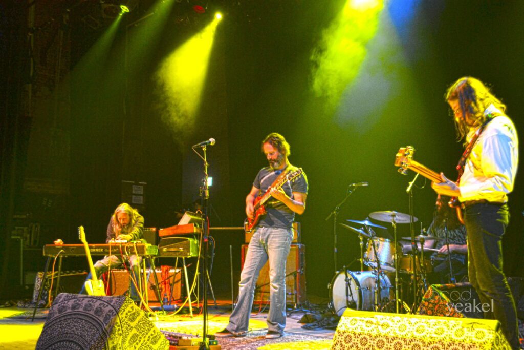 Band performing on stage under colorful lights.