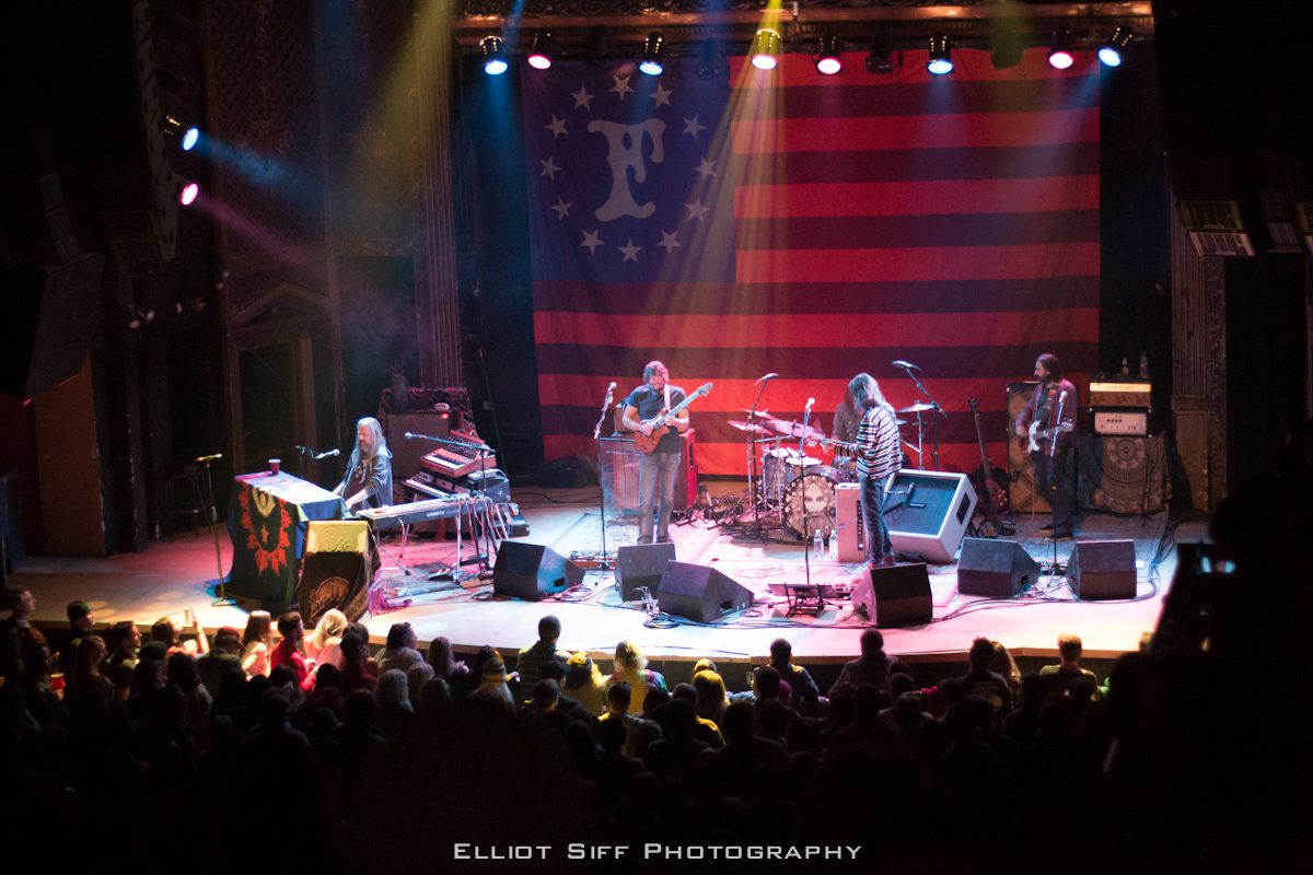 Live band performing on stage with audience.