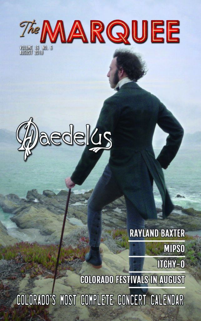 Man with cane overlooking a rocky landscape.