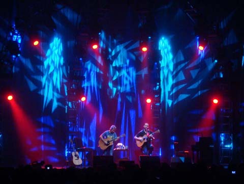 Musicians performing on stage with colorful lights.