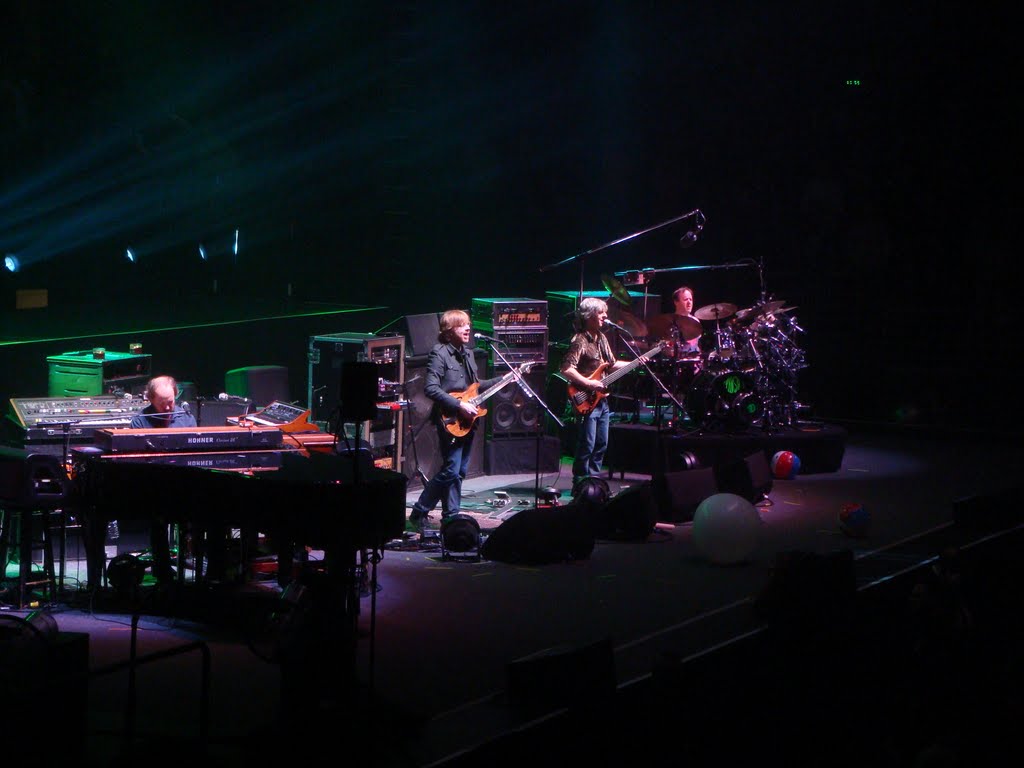 Band performing live on stage with instruments.