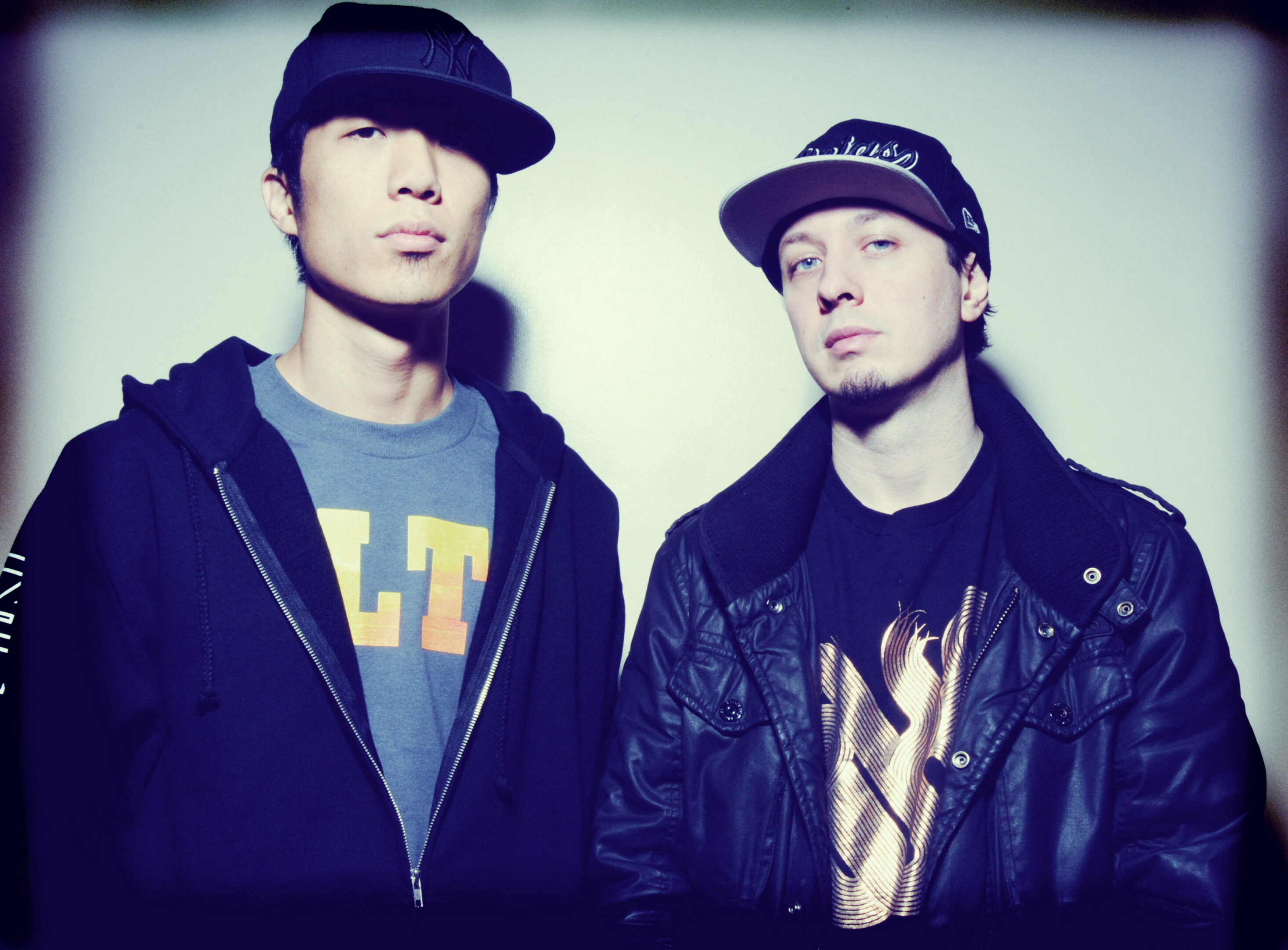 Two men wearing caps and casual jackets.