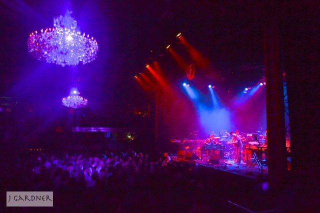 Concert stage with colorful lights and chandeliers.