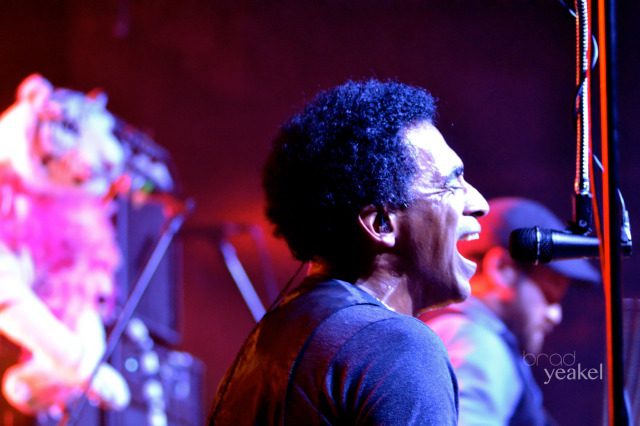 Musician singing passionately into a microphone.
