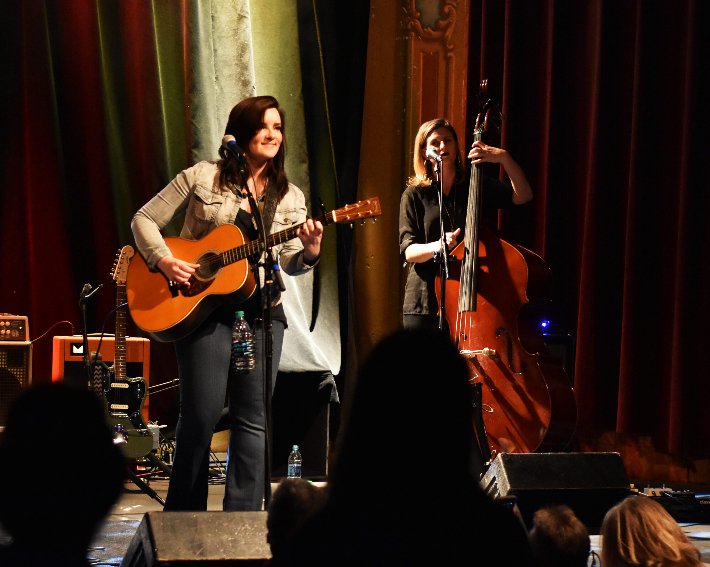 Musicians performing on stage with instruments.