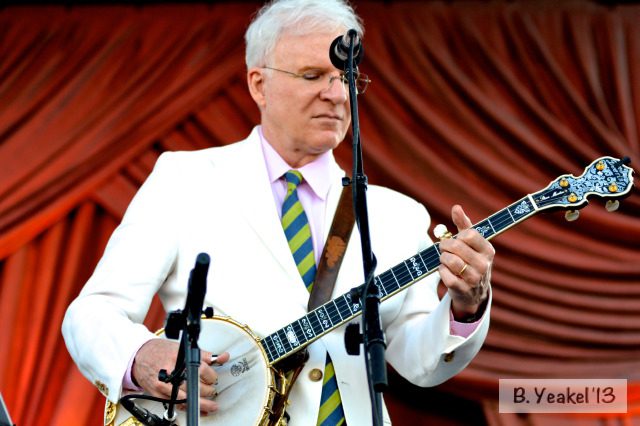 Man playing banjo on stage.