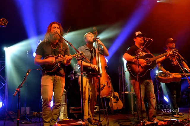 Band performing on stage with colorful lights.