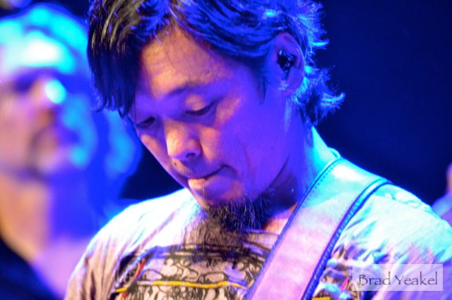 Guitarist performing under blue stage lights.