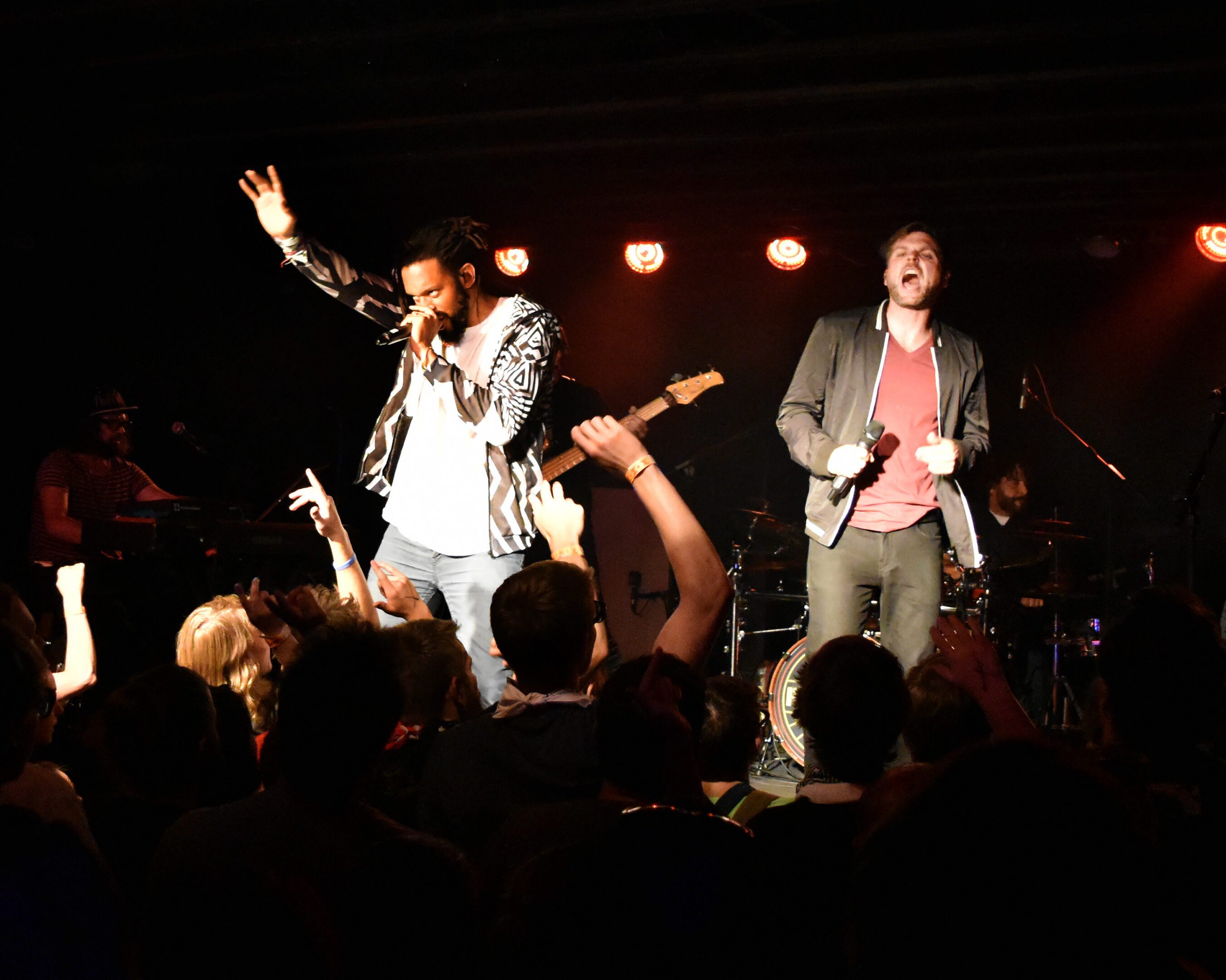 Live band performing on stage with crowd.
