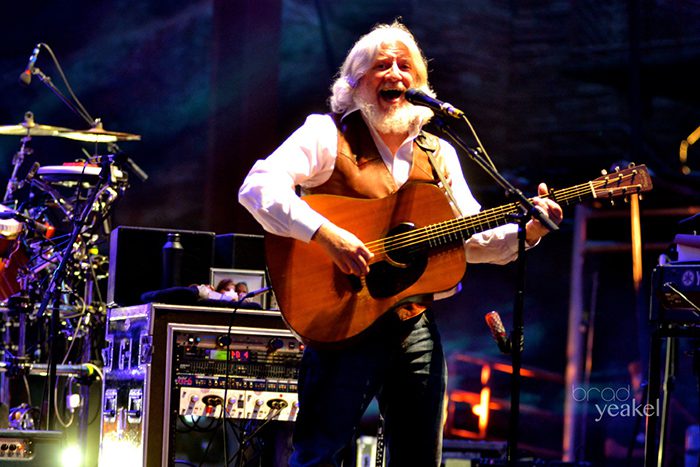 Musician performing on stage with guitar.