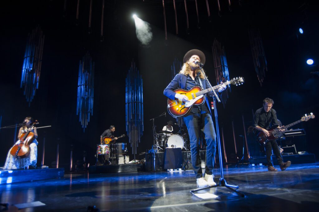 Band performing live on stage with instruments.
