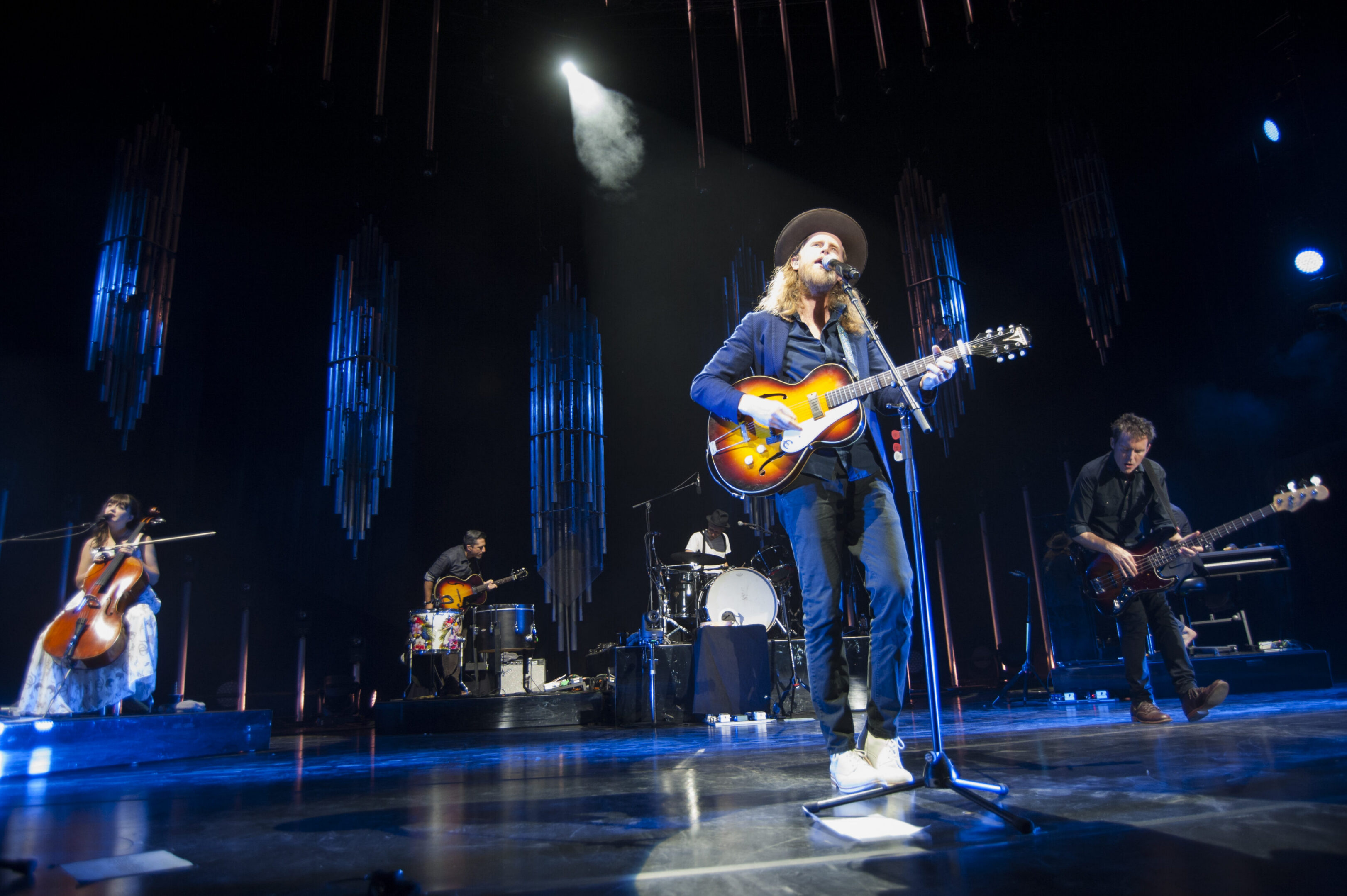 Band performing live on stage with instruments.