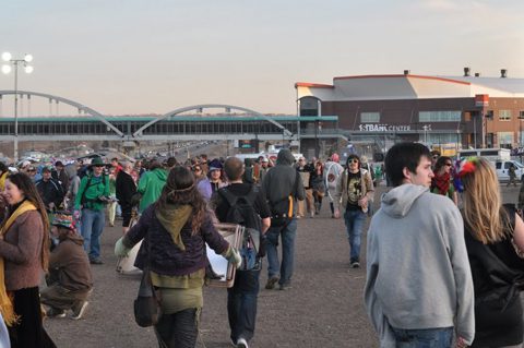 Outdoor crowd near a large event center.
