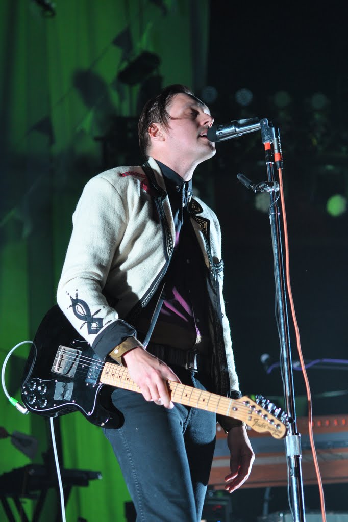 Musician performing on stage with guitar.