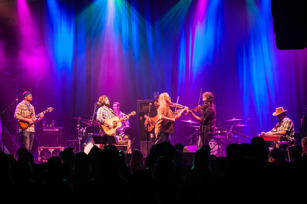 Band performing on stage with colorful lights.
