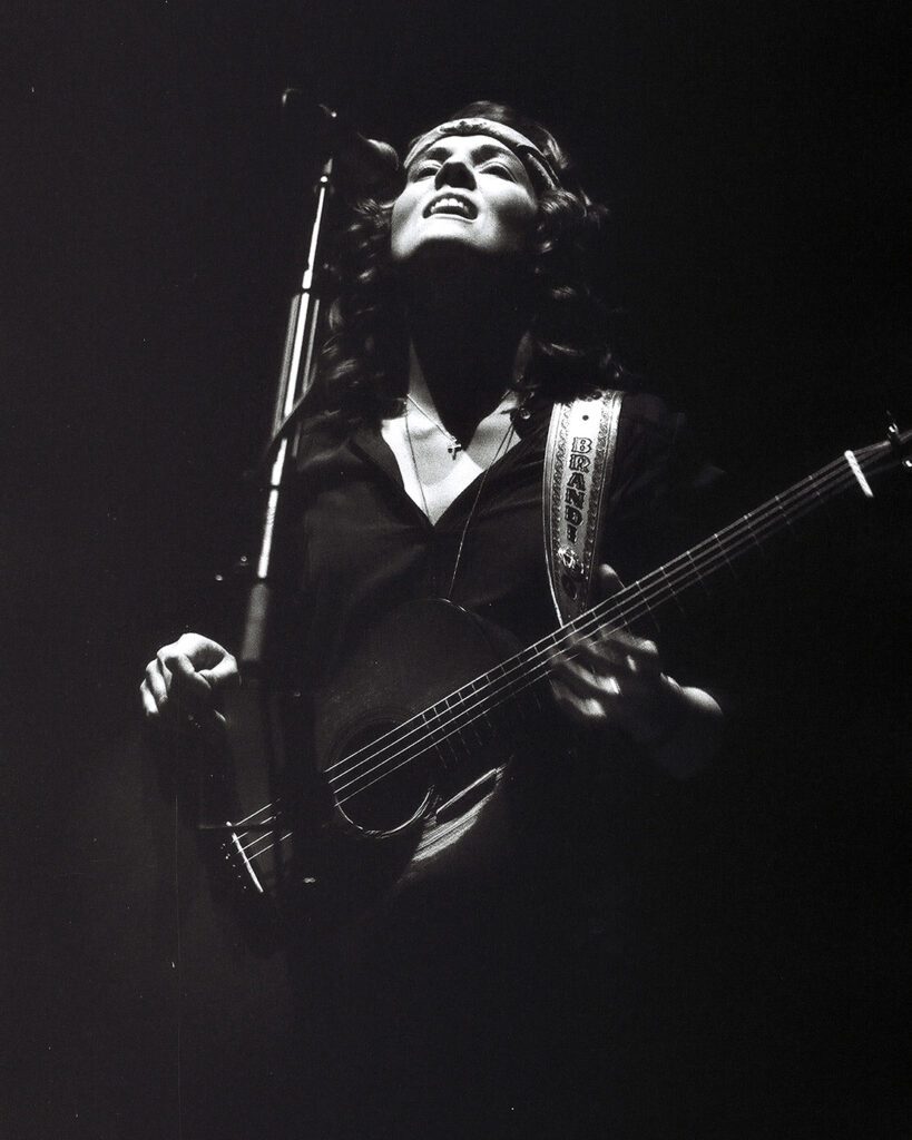 Musician passionately playing guitar on stage.