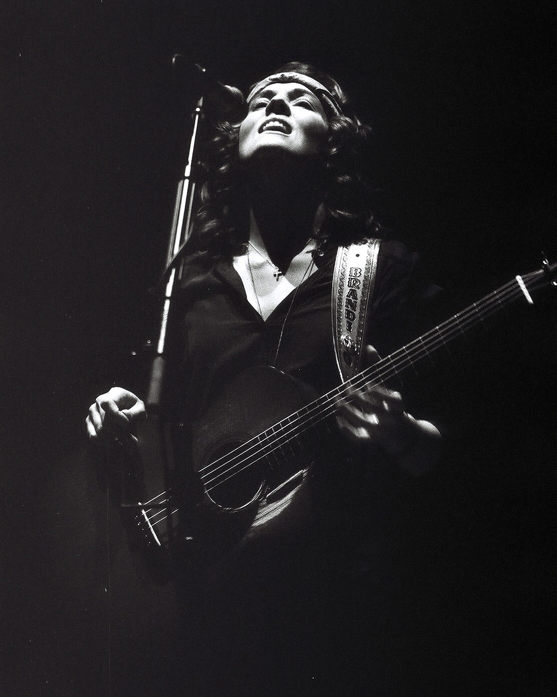 Musician passionately playing guitar on stage.