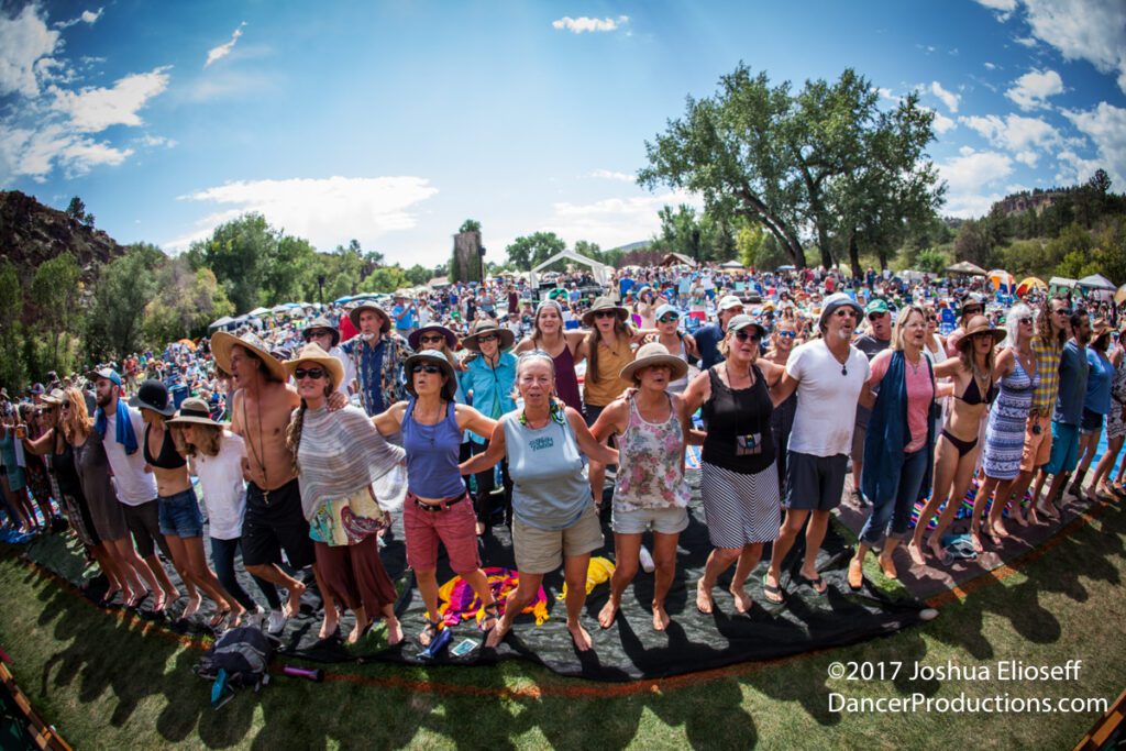 Crowd at outdoor festival, standing together.