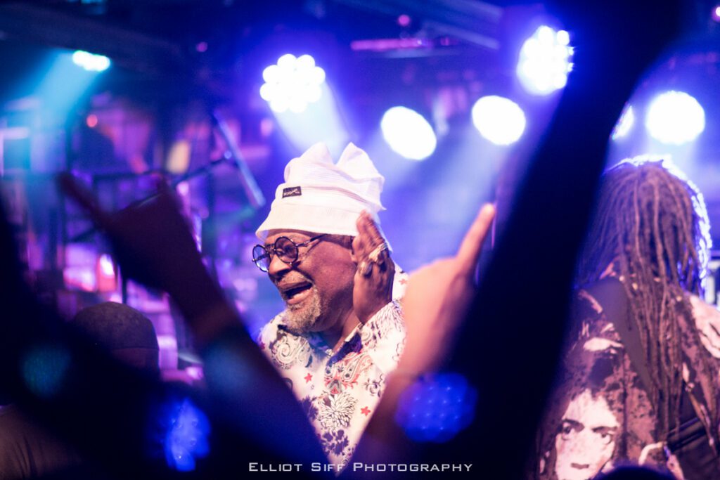 Musician performing on stage with bright lights.
