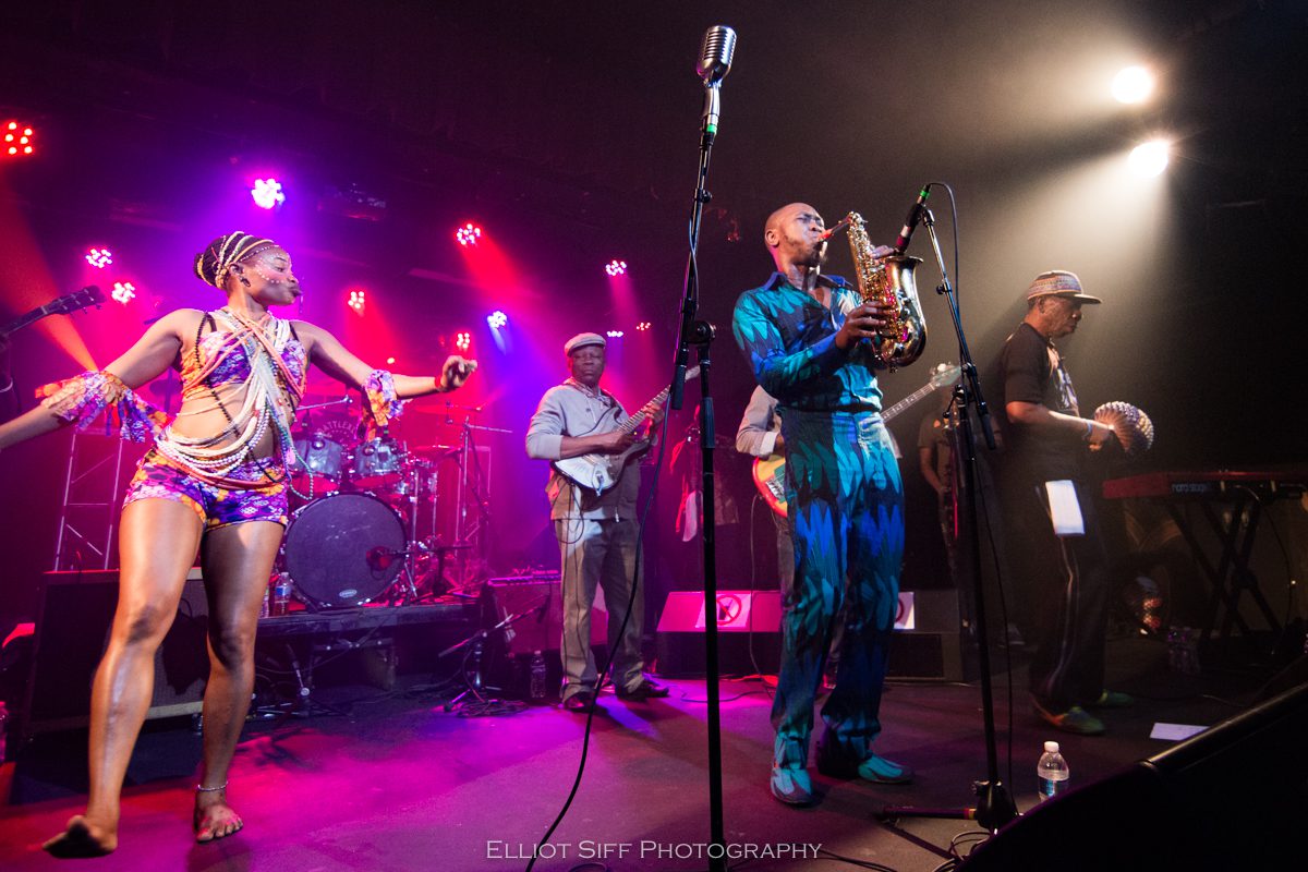 Live band performing on colorful stage.