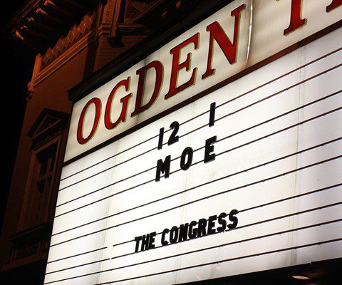 Theater marquee displaying event information at night.
