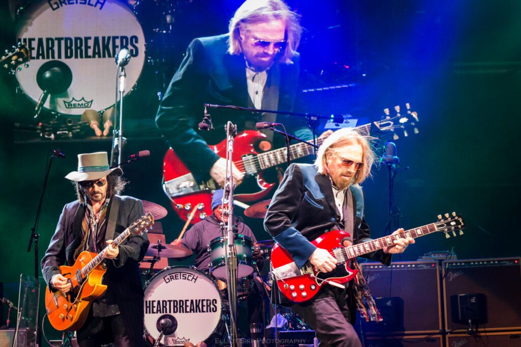 Musicians performing on stage with guitars.