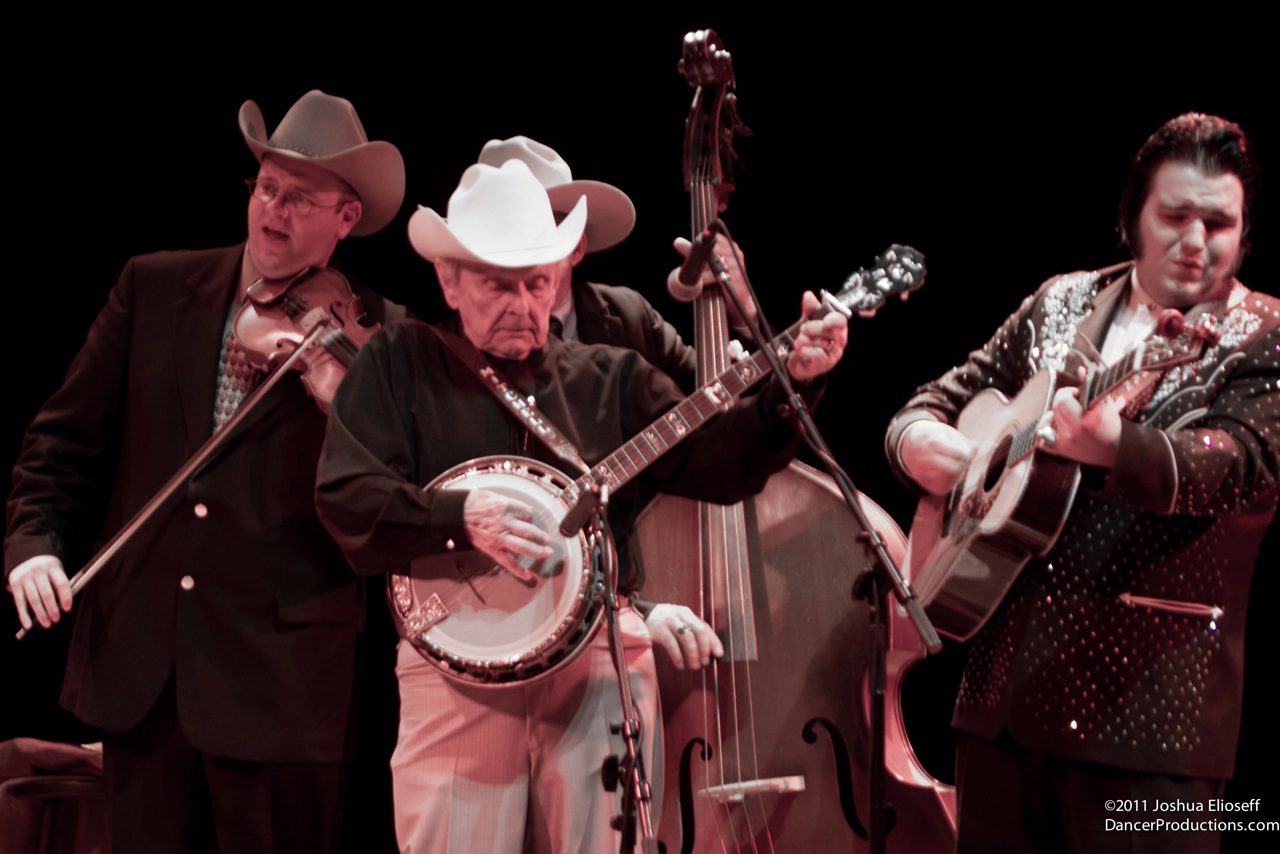 Country musicians performing with instruments on stage.