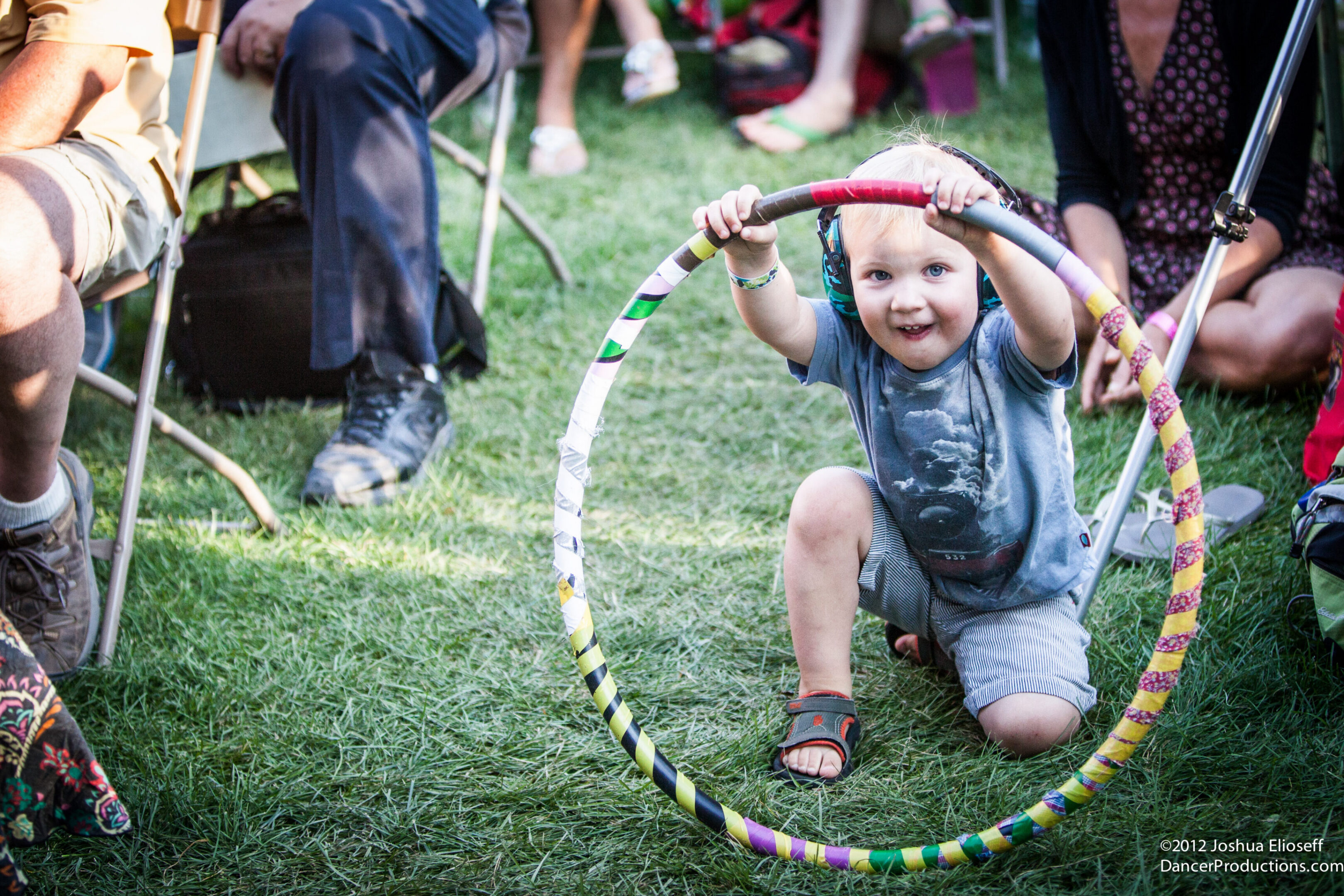 Child playing with a colorful hula hoop.