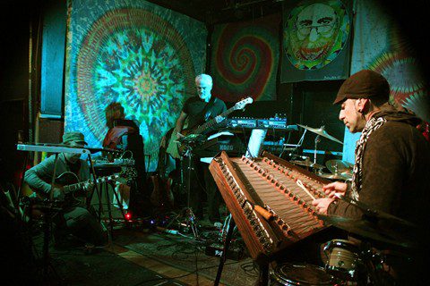 Musicians performing with colorful psychedelic backdrops.