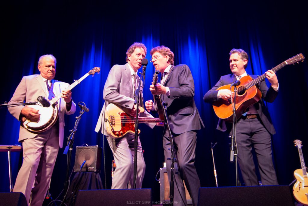 Band performing live on stage with instruments.