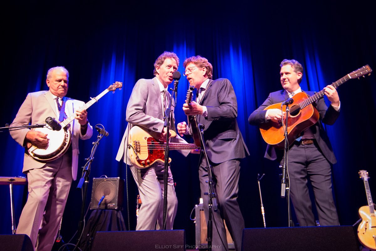 Band performing live on stage with instruments.