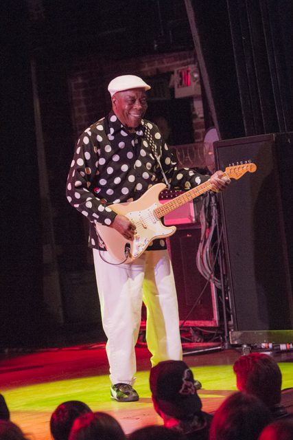 Man playing electric guitar on stage.