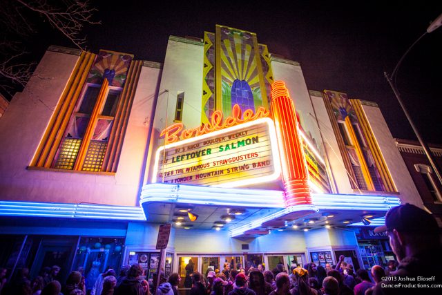 Colorful theater marquee with crowd outside at night.