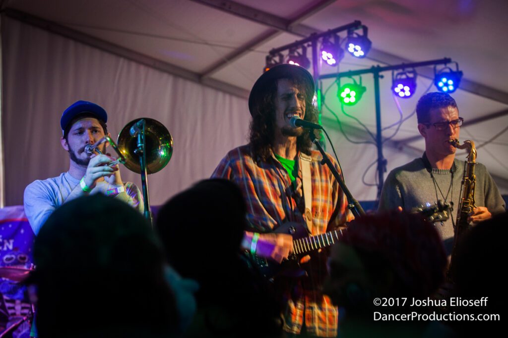 Band performing on stage with colorful lights.