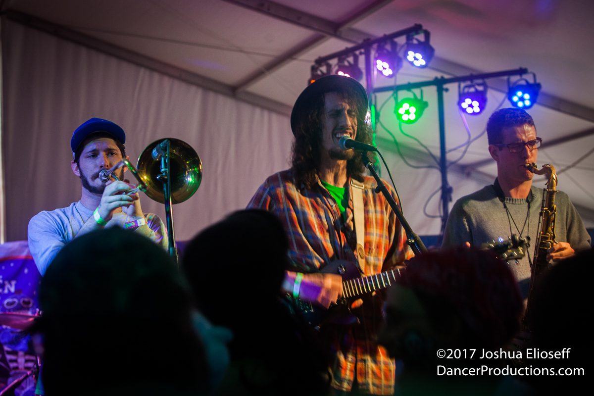 Band performing on stage with colorful lights.