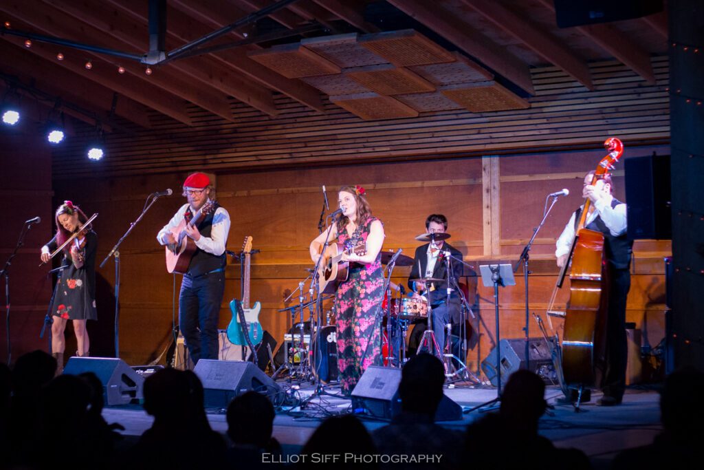 Band performing on stage with instruments.