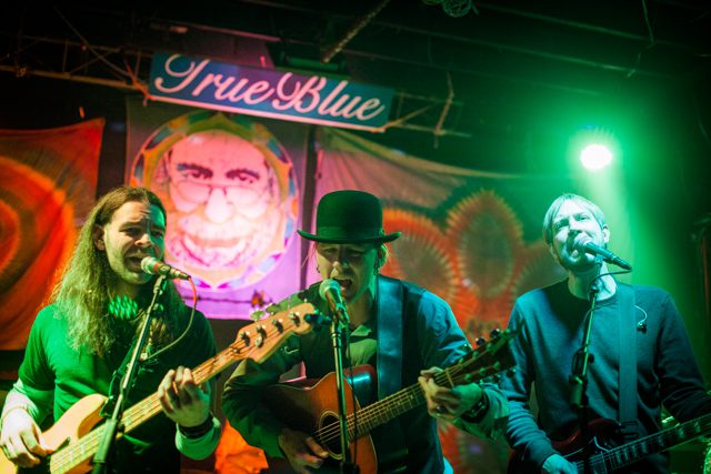 Band performing live on colorful stage.