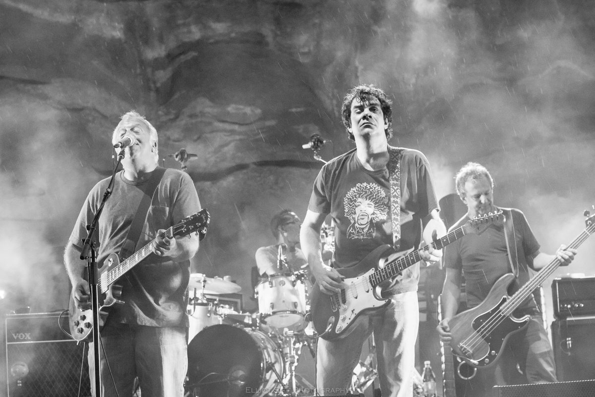 Rock band performing on stage with guitars.