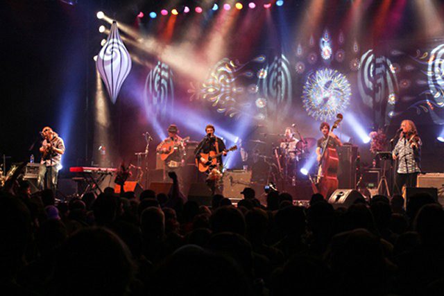 Band performing on stage with colorful lights.