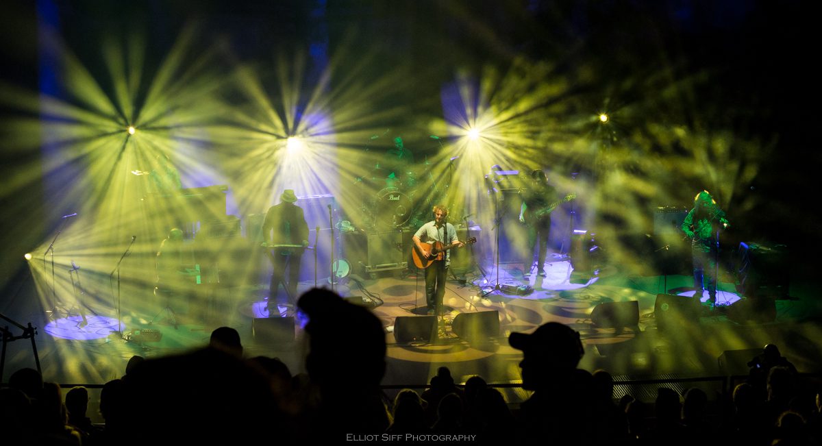 Band performing on stage with colorful lights.
