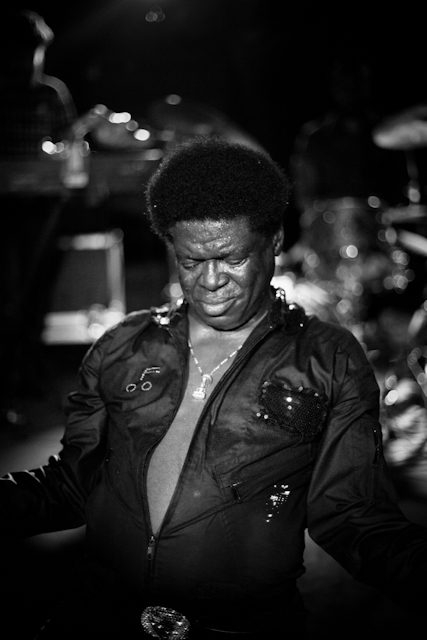 Singer performing passionately on stage, black-and-white.