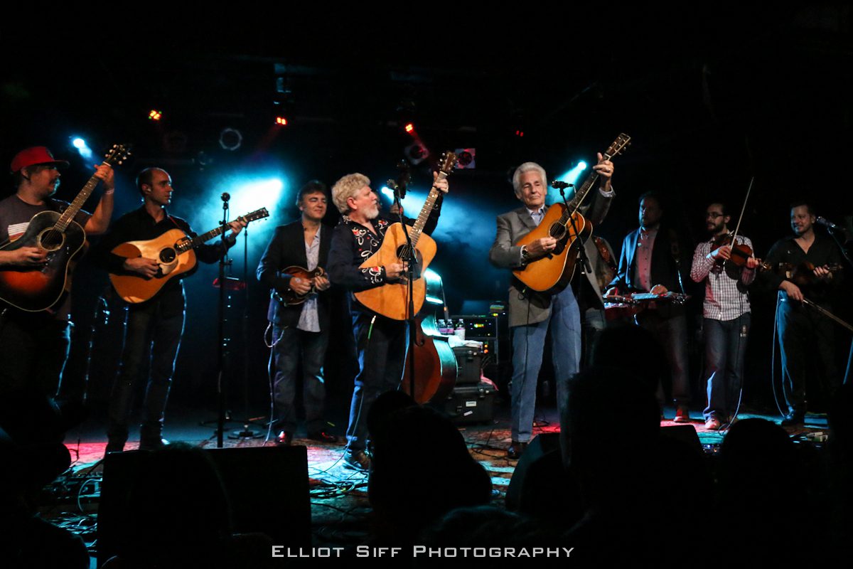 Band performing live on stage with guitars.