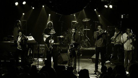 Band performing on stage with instruments.