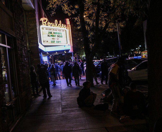 People outside Boulder theater at night.