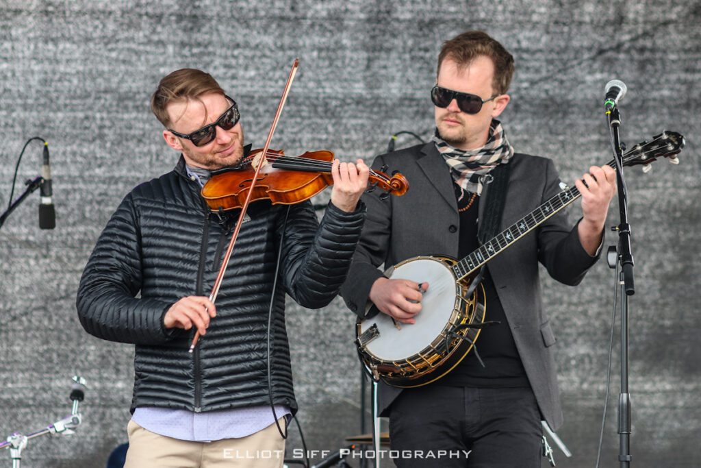 Musicians playing violin and banjo on stage.
