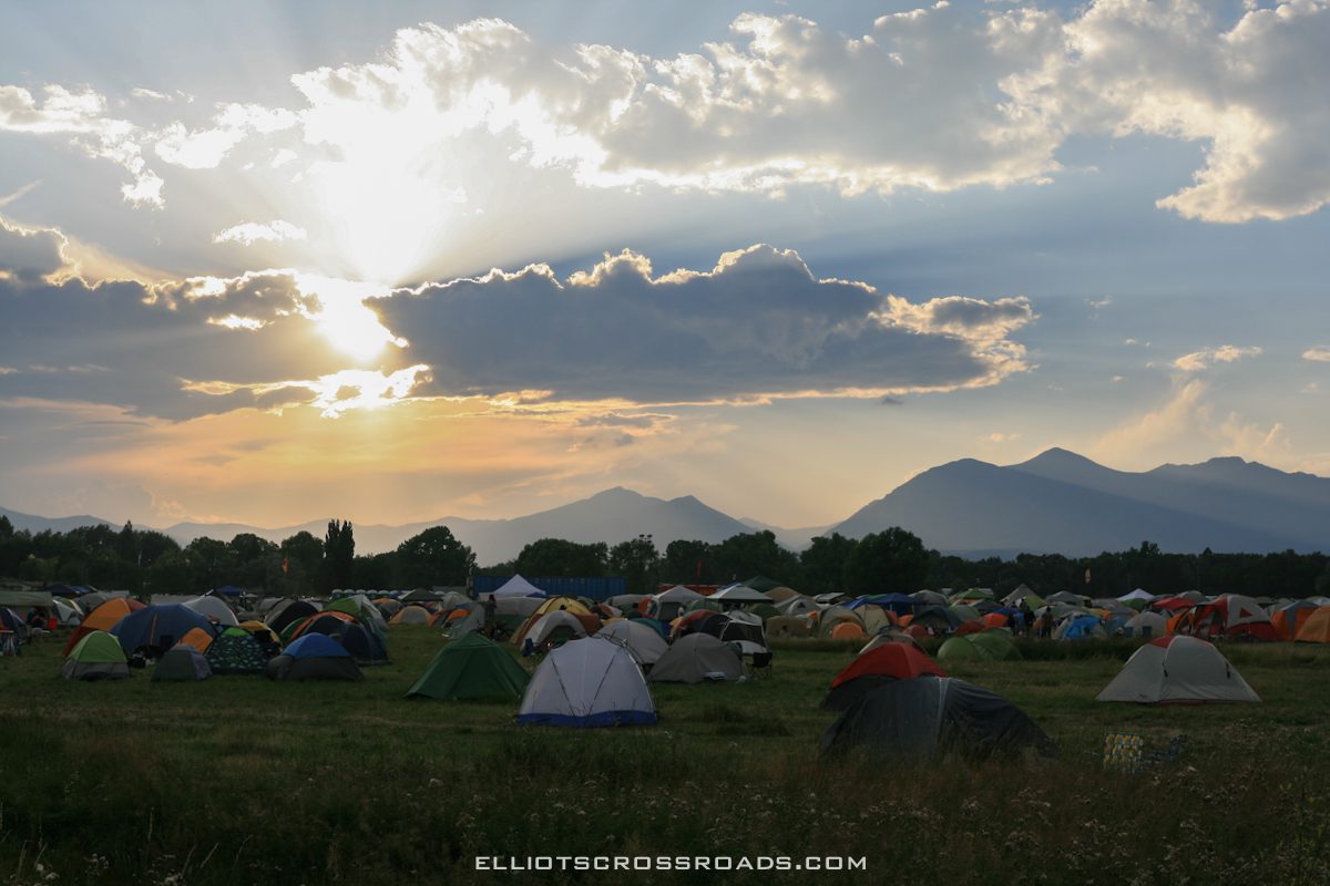 Tents in a field at sunset.