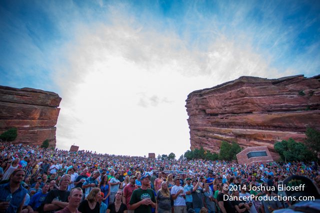 Crowd gathered at outdoor amphitheater under sky.